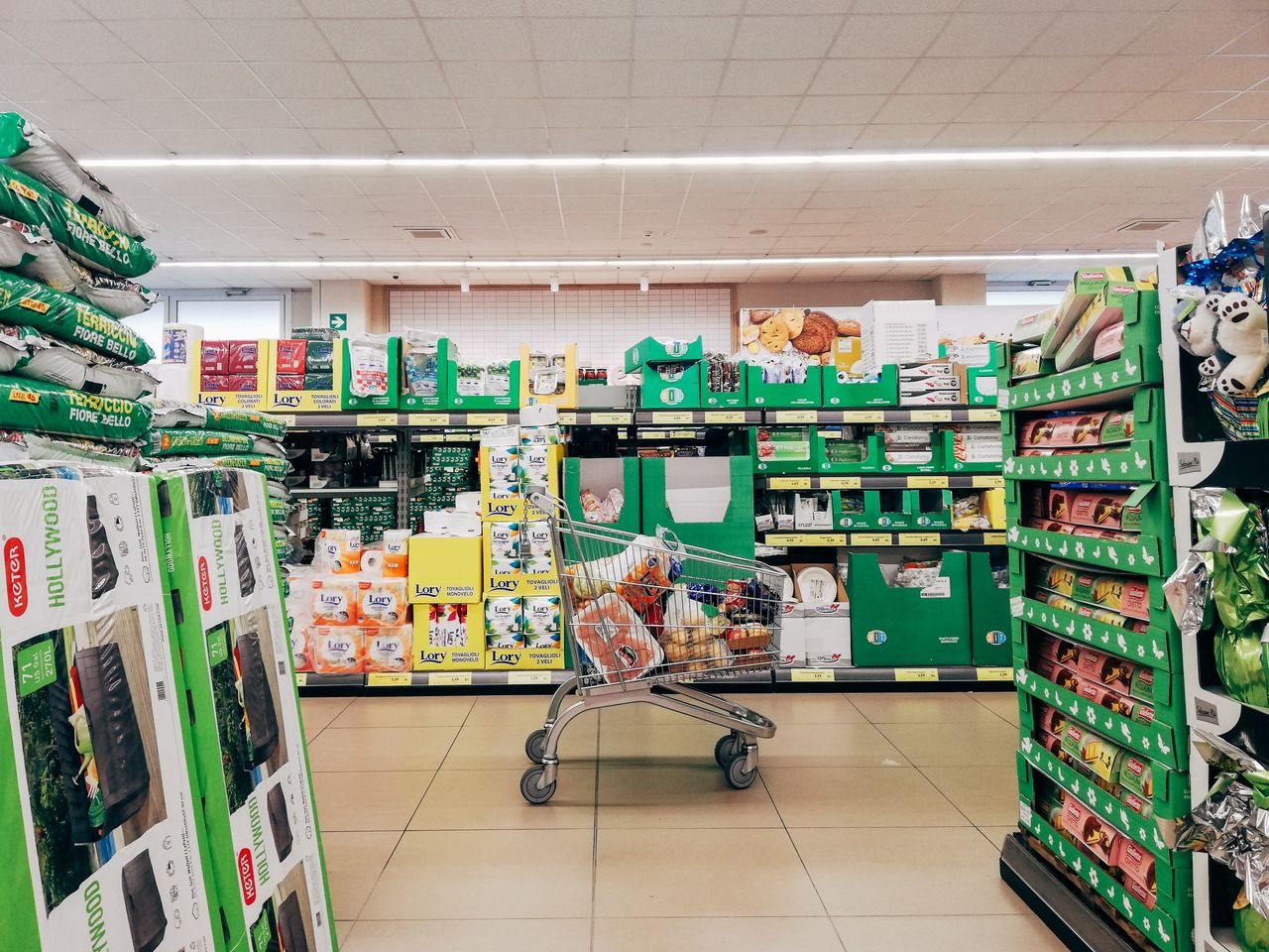 Free Shopping cart in a vibrant supermarket aisle in Padova, Italy. Stock Photo