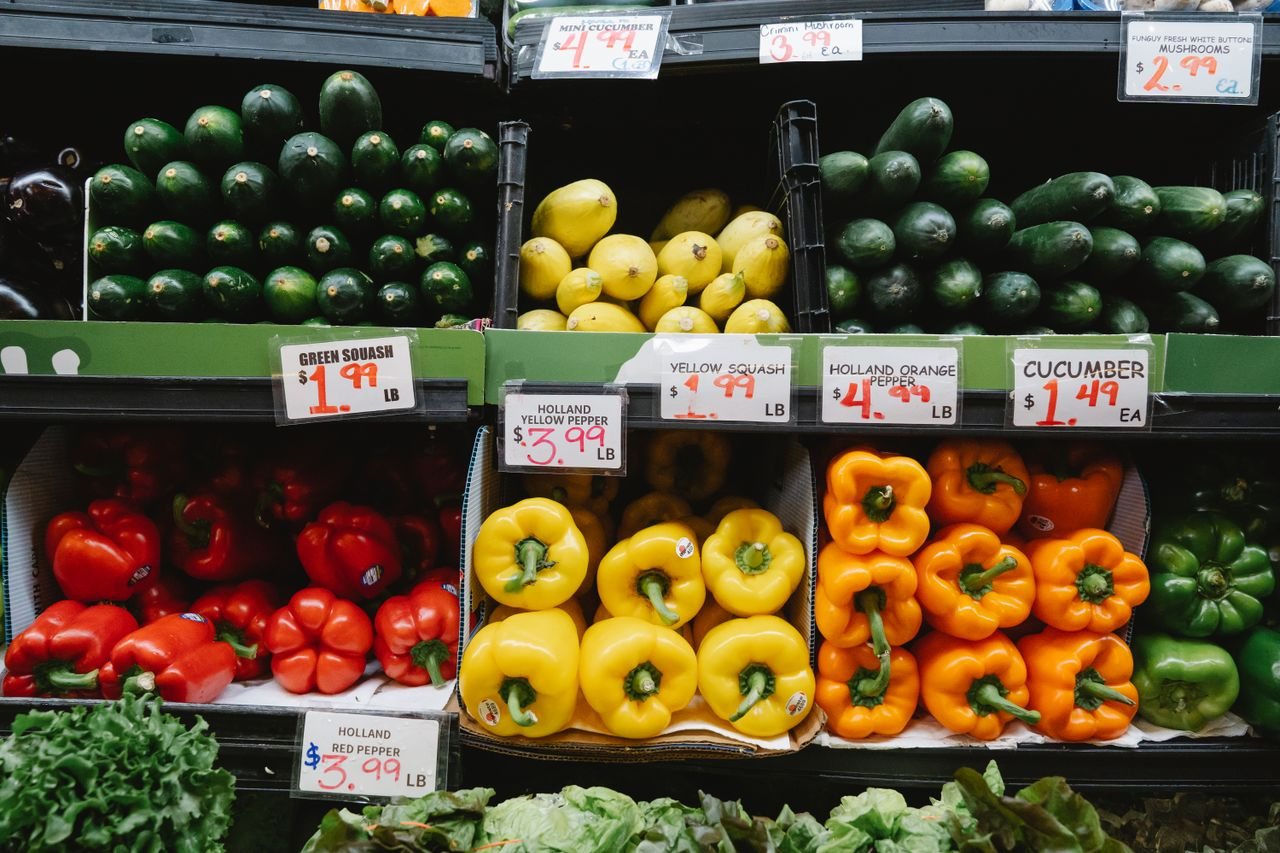 Free Colorful assortment of fresh vegetables at a supermarket display, highlighting peppers, squash, and cucumbers. Stock Photo